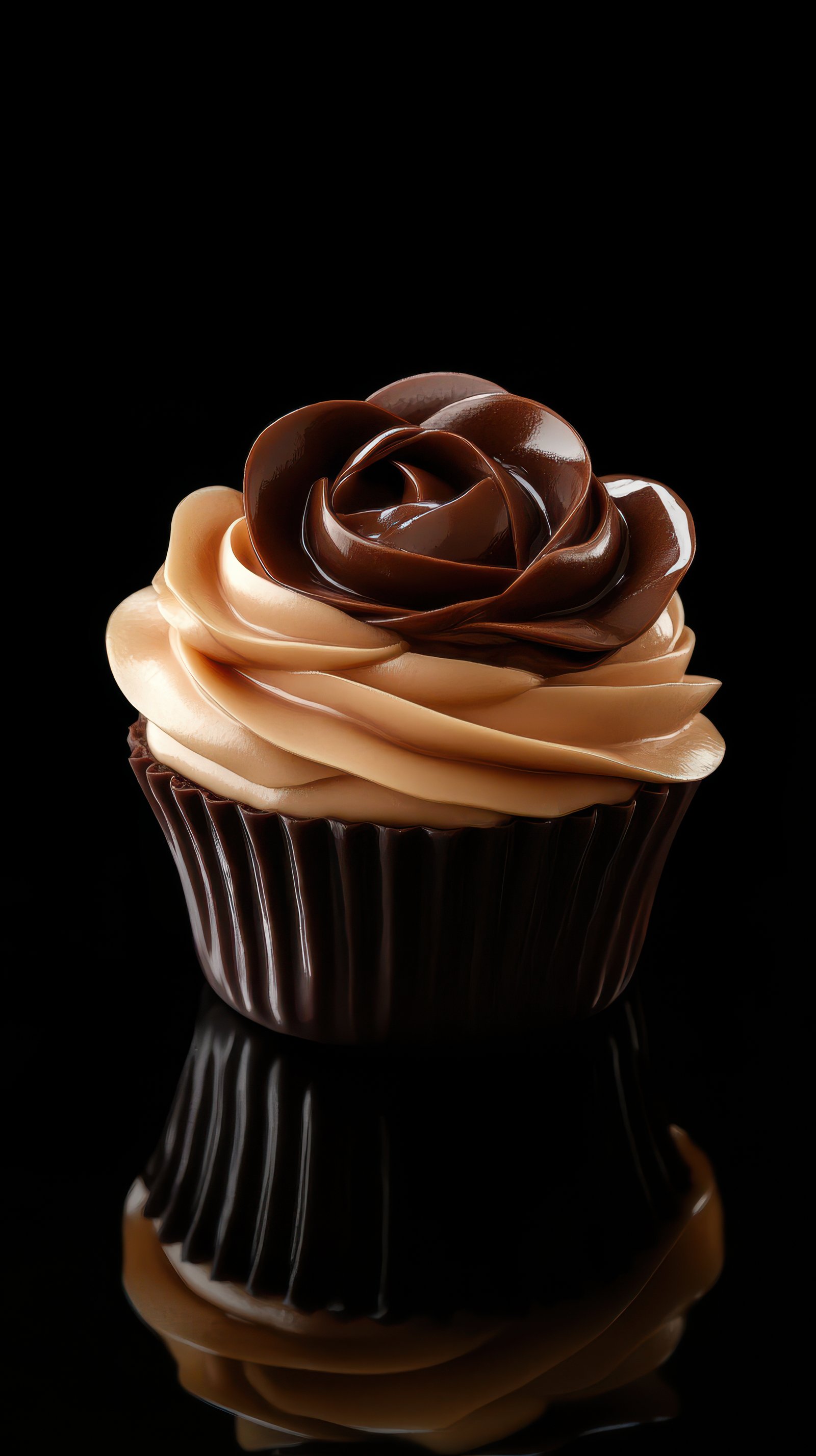 A chocolate cupcake with a swirl of caramel frosting and a chocolate rose on top sits on a black surface